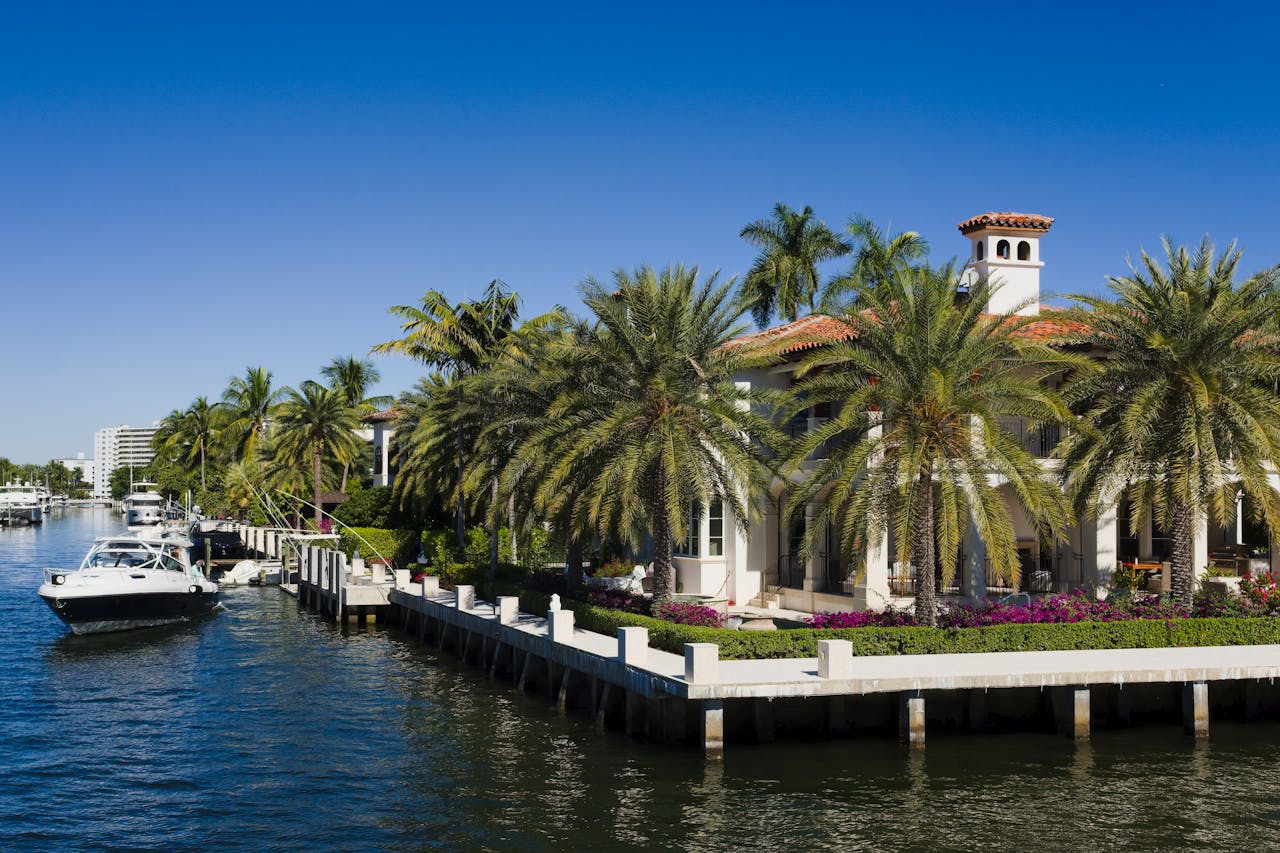 A view of boats on a river near the palm trees and mansions in Fort Lauderdale, Florida
