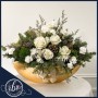 A gold boat flower arrangement with white roses